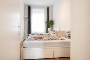 a white bed sitting under a window in a room at City-Apartments Graz in Graz