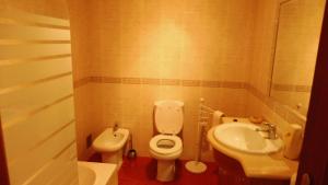 a small bathroom with a toilet and a sink at GBT Quartos in Sines