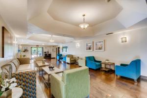 sala de estar con sofás, mesas y sillas azules en Orangewood Inn and Suites Midtown, en Austin