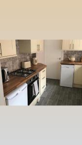 a kitchen with white cabinets and a stove top oven at Seascape in Whitley Bay