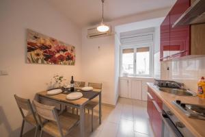 a kitchen with a table and chairs and a sink at Aurora Apartment Zadar in Zadar