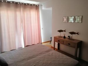 ein Schlafzimmer mit einem Bett und einer Kommode mit zwei Lampen in der Unterkunft Apartamento Duplex - Cabanas Garden in Tavira