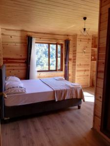 1 dormitorio con 1 cama en una habitación de madera en Viceminiotel, en Rize