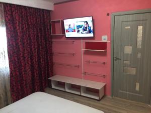 a bedroom with red walls and a tv on a wall at Ultracentral zona zero apartament in Bacău