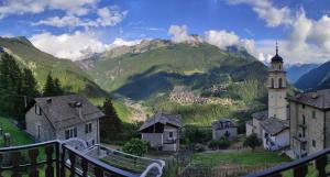 a view of a village with a church and mountains at Ca' del bau in Chiesa in Valmalenco