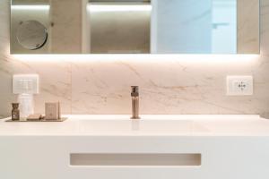 a bathroom counter with a sink and a mirror at THE ONE CAORLE - Hotel & Apartments in Caorle