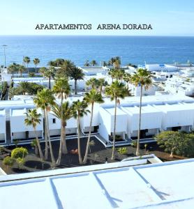 einen Luftblick auf ein Resort mit Palmen und dem Meer in der Unterkunft Apartamentos Arena Dorada in Puerto del Carmen