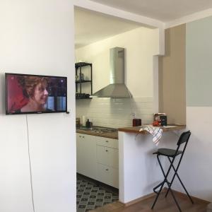 a kitchen with a tv on a white wall at Utešené Apartmány - Bratislava - Trnavské mýto in Bratislava