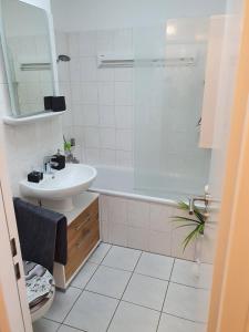 y baño blanco con lavabo y bañera. en Exklusivwohnung Leipzig Flughafen, en Landsberg