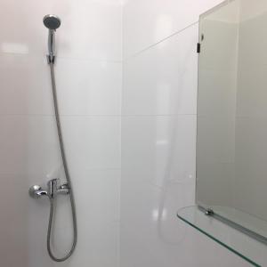 a shower with a shower head in a white bathroom at Utešené Apartmány - Bratislava - Trnavské mýto in Bratislava