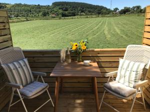 a table and chairs on a deck with a field at The Loft at 522 in Woodburn