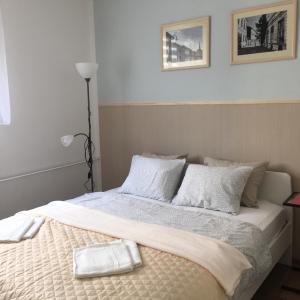 1 dormitorio con 1 cama con sábanas y almohadas blancas en Utešené Apartmány - Bratislava - Trnavské mýto en Bratislava