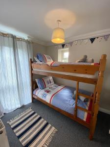 a bedroom with two bunk beds and a rug at Crofton House Garden Apartment in Ryde