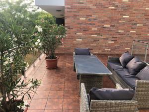a patio with a table and chairs and a brick wall at Castellum Apartmanház in Gyula