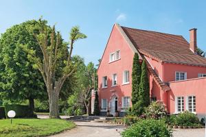 a red house with a tree in front of it at Le Clos Fleuri - Maison Vigier in Maringues