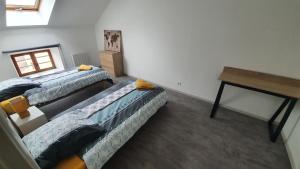 a room with three beds and a desk in it at Les Gîtes de Jussey in Jussey