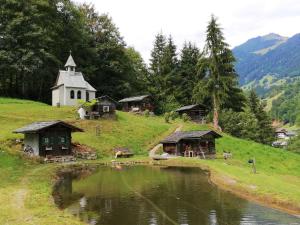 a church sitting on top of a hill next to a lake at Ferienhaus Hämmerle´s in Lustenau