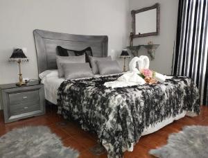Un dormitorio con una cama con dos cisnes. en La Riguera De Ucieda, en Ucieda de Arriba