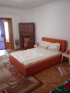 a large bed in a room with a fireplace at Amya - Centrul istoric in Braşov