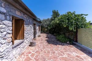 kamienny chodnik obok kamiennego budynku w obiekcie Boutique Stone Cottage w mieście Dhímaina