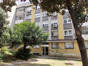Un edificio de apartamentos con árboles en frente. en Sasa's Apart, en Vračar (historical)