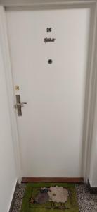 Una puerta blanca con un cartel en una habitación en Sasa's Apart, en Vračar (historical)