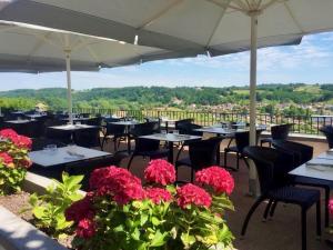 a restaurant with tables and chairs and flowers at Hotel Residence Bellevue in Cambo-les-Bains