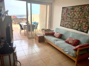 ポリス・デ・アボナにあるRelax and Quiet Apartment for remote working, with wonderful sea views in Poris de Abona, Tenerife - Canary Islandsのリビングルーム(ソファ付)が備わり、パティオの景色を望めます。
