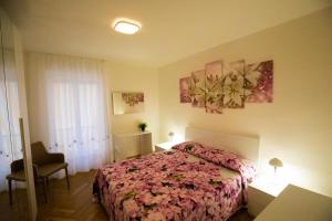 1 dormitorio con 1 cama, 1 silla y 1 ventana en Lorenzo's Apartament en Aosta