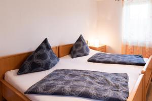 two beds with pillows on them in a bedroom at Ferienwohnung Andreas in Tettnang