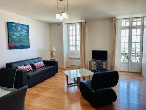 - un salon avec un canapé noir et une table en verre dans l'établissement Hotel Residence Bellevue, à Cambo-les-Bains