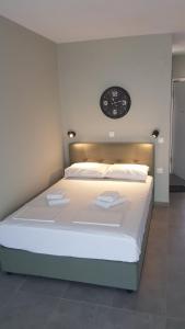 ein Schlafzimmer mit einem großen Bett mit einer Uhr an der Wand in der Unterkunft Iasonas View Studio in Néa Péramos