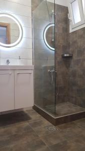 ein Badezimmer mit Dusche und Waschbecken in der Unterkunft Iasonas View Studio in Néa Péramos