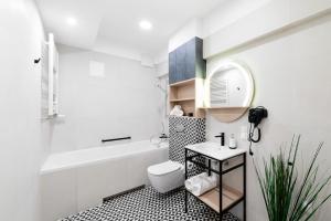 a bathroom with a sink and a toilet and a tub at Hotel Tulip Residences Warsaw Targowa in Warsaw