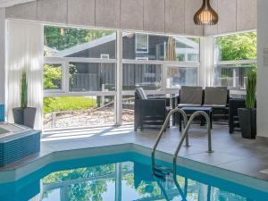 a house with a swimming pool and a dining room at 12 person holiday home in Glesborg in Glesborg