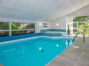 a swimming pool with blue water in a house at 12 person holiday home in Glesborg in Glesborg