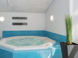 a jacuzzi tub in a bathroom with blue tiles at 12 person holiday home in Glesborg in Glesborg