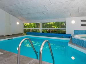 a swimming pool in a house with blue ceilings at 12 person holiday home in Glesborg in Glesborg
