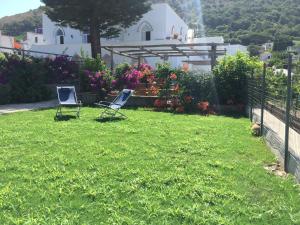 two chairs sitting in the grass in a yard at Casa Adriana in Anacapri