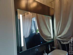 a bathroom mirror with a sink and a window at Valeria's Nest in Reşiţa +12 photos