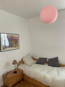 トゥルヴィル・シュル・メールにあるMaison de pecheurのベッドルーム(ベッド1台、ピンクのランプ付)