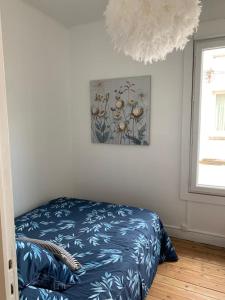 トゥルヴィル・シュル・メールにあるMaison de pecheurのベッドルーム1室(ベッド1台付)が備わります。壁に絵が飾られています。