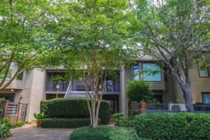 a building with trees and bushes in front of it at Bohicket Marina Condo in Seabrook Island