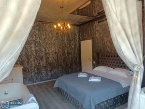 a bedroom with a bed and a chandelier at Valeria's Nest in Reşiţa