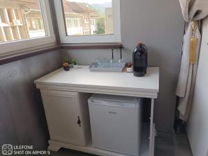 a small white table with a sink and a window at Valeria's Nest in Reşiţa