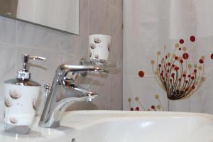 um lavatório de casa de banho com uma torneira e duas chávenas em VillaRosa em Lotzorai