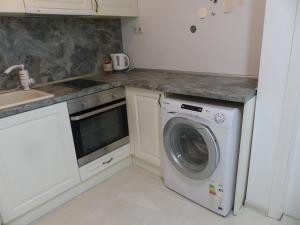 a kitchen with a washing machine and a sink at Apartament HOLIDAY in Burgas City