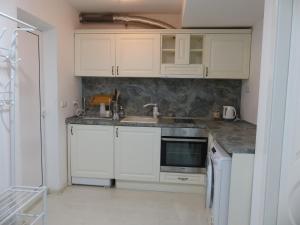 a kitchen with white cabinets and a sink at Apartament HOLIDAY in Burgas City