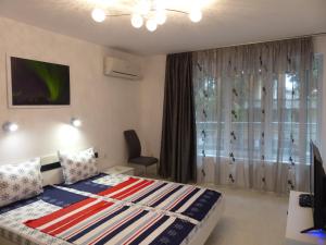 a bedroom with a bed and a window at Apartament HOLIDAY in Burgas City