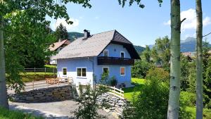 una casa blanca con techo de pizarra en Ferienhaus Lungau Home, en Mariapfarr